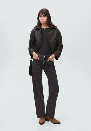 Črno denimska jakna čez črno majico, v kombinaciji z visoko pasom, temno sivo jeans hlačami in rjavimi chelsea škornji na peto. Preproste, čiste linije.