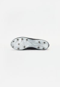 Semelle de chaussures de soccer noire avec une plaque translucide et des crampons disposés de manière proéminente pour une traction optimale. Détails de surface texturée visibles.