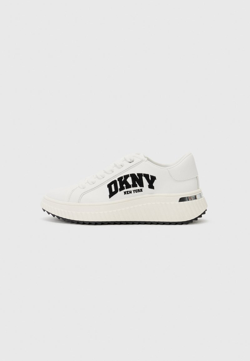 Hvite lærersneakers med DKNY-logo i svart, strukturert gummisåle, og en kontrastfarge i sølv på hælen.