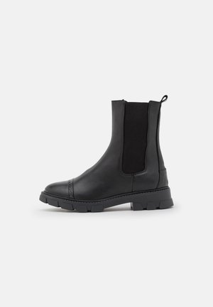 Zwarte leren Chelsea-boots met elastische zijkanten, ronde neus en robuuste rubberen zool. Kenmerkt stikseldetails en een trekband.