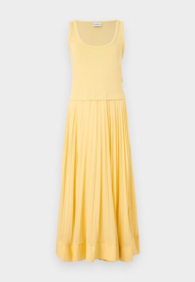 Kätse kõrvariga kollane kleit, millel on istuv korpus ja volditud, voolav seelik. Pehme kangas sileda tekstuuriga ja delikaatne äärise detail.