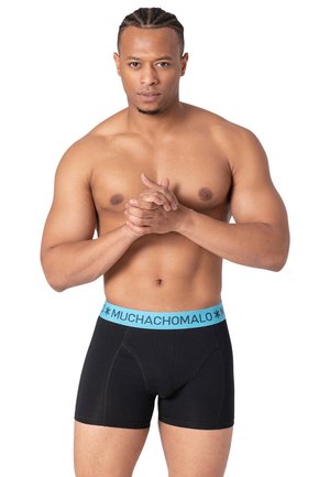 Schwarze Boxershorts mit einem hellblauen Bund, der mit "MUCHACHOMALO" beschriftet ist. Der Stoff wirkt glatt, hat eine enganliegende Form und einen leichten Stretch.