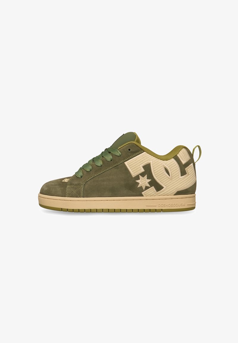 Baskets basses en daim vert olive avec semelle beige et grand logo DC beige sur le côté, lacets verts et languette au talon.