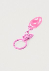 Ružový plastový kľúčenka s kruhovým krúžkom, spojeným reťazcom a klipom. Na hornom oblúku je motív znamenia mieru. Hladká textúra.
