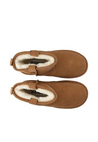 Brown suede ankle boots with fur lining, featuring a rounded toe and two side straps for closure. Smooth texture and simple design.