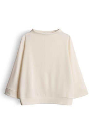 Crèmekleurige geribbelde top met een boothals, brede driekwart mouwen en een losse pasvorm. Zachte textuur met een gladde afwerking.