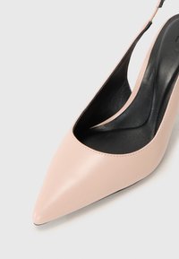 Pumps slingback in pelle rosa con punta affusolata, interno nero elegante e superficie liscia. Cuciture sottili lungo il bordo.