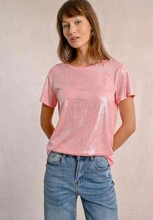 T-shirt rosa lucido a maniche corte con una vestibilità rilassata, abbinato a jeans in denim azzurro chiaro. Design semplice e texture liscia.