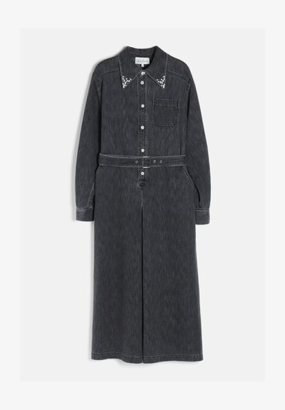 Robe longue en denim noir avec manches longues, taille ceinturée, poche avant, fermeture par boutons et broderie blanche décorative sur le col.