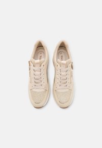 Beige sneakers met een mix van gladde en gestructureerde materialen, vetersluiting en een gouden ritsaccent aan de zijkant.