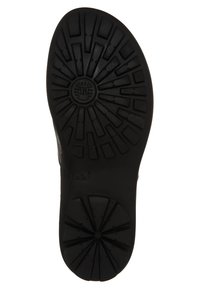 Black rubber shoe sole with a patterned tread design, featuring a circular logo in the center and textured surface for traction.