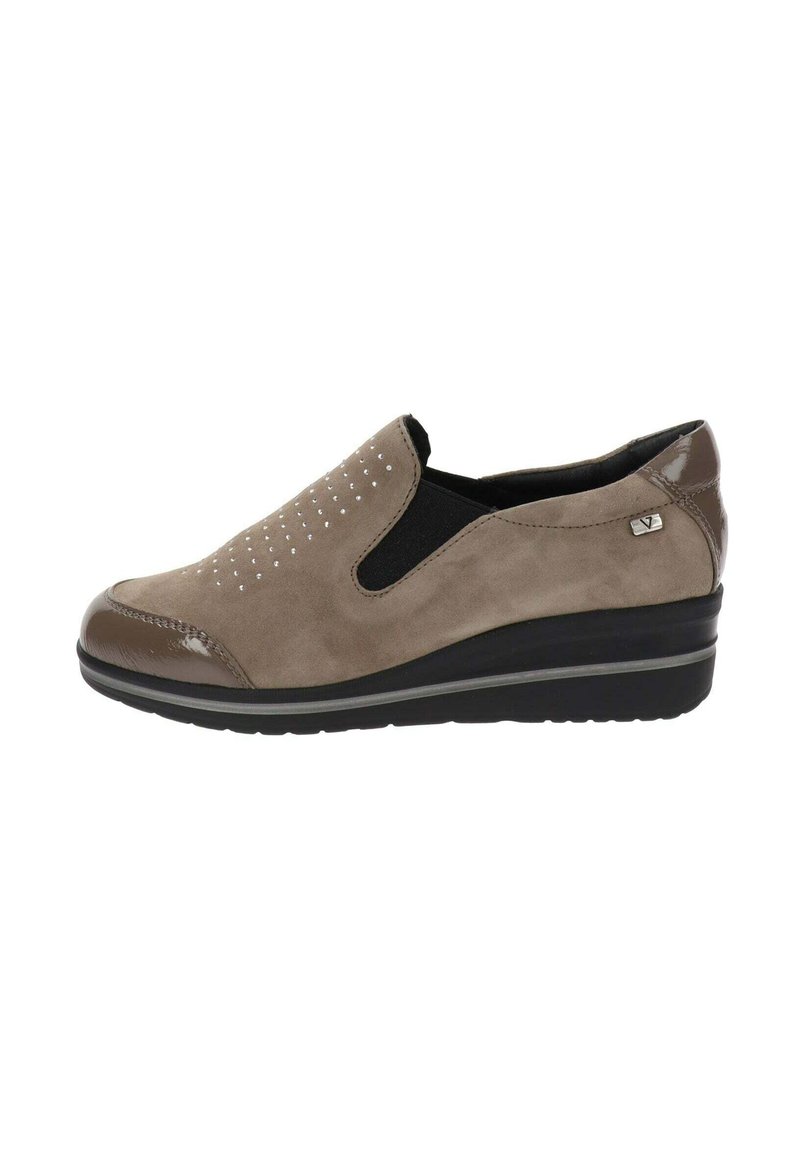 Scarpa slip-on beige con punta in vernice liscia, design perforato sulla tomaia e un pannello elastico laterale nero testurizzato. Presenta un tacco basso a cuneo.
