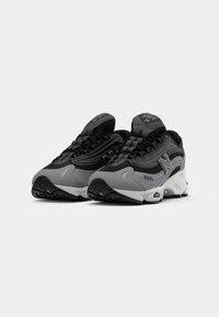 Pair of black and gray New Balance 1000 sneakers with white midsoles, mesh and synthetic uppers, positioned side by side on white background.