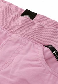 Pink fabric shorts featuring a ribbed waistband, front pocket, and black tag with "VILLET" label. Smooth texture and casual design.