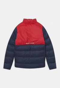 Červená a námořnická pufovaná bunda s stojáčkem, nabízející horizontální design, prošívanou texturu a logo "Helly Hansen" na zadní straně.