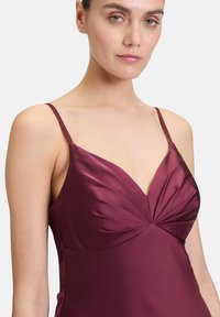 Burgunderrotes Satin-Kleid mit V-Ausschnitt, dünnen Trägern und Faltendetails am Oberteil, das eine glatte, fließende Silhouette schafft.