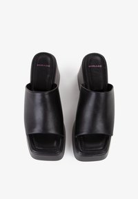 Sandali slide in pelle nera con una ampia fascia superiore, design a punta quadrata e tacco a zeppa spesso. Include logo del marchio embossato in rosa.