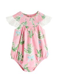 Rózsaszín pamut overál zöld és kék virágmintával, gyűrt nyakkivágással és fehér csipkés ujjakkal; patentos rögzítés az alján.