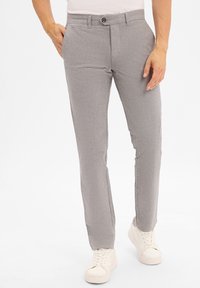 Grijze, gestructureerde broek met een rechte pasvorm, voorzien van een knoopsluiting en zijzakken. Draagt met witte sneakers.