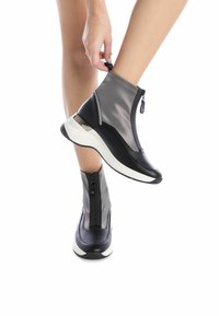 Botas altas con una combinación de materiales en gris y negro, que cuentan con un cierre de cremallera y una suela blanca. Los acentos texturizados añaden detalle.