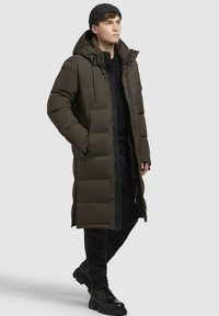 Langdonkergroen puffer jacket met een capuchon, voorkant rits en twee zijzakken; heeft een gestructureerde afwerking en verstelbare trekkoorden.