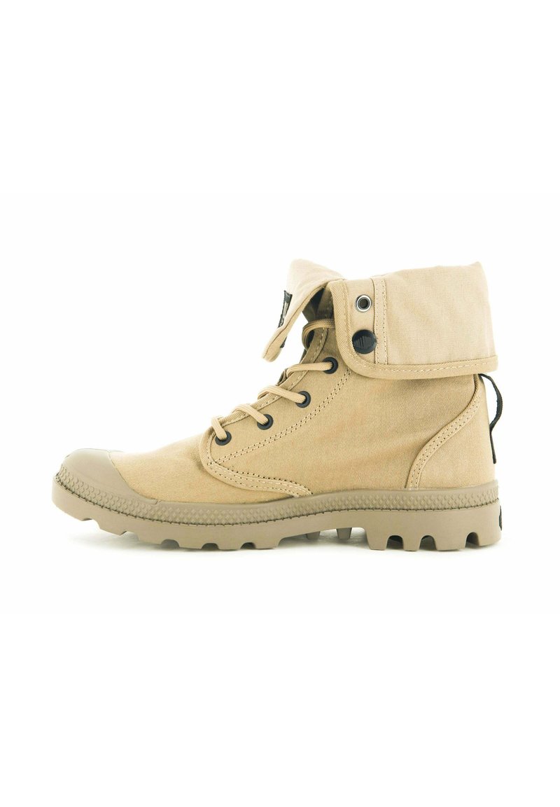 Beige canvas ankelstövel med vikbar krage, rund tå, metalöljetter och en robust sula med stora mönster för bra grepp.