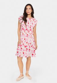 Robe florale avec de courtes manches à volants, présentant une base rose recouverte de fleurs rouges et roses. Tissu doux, design mi-long, coupe décontractée.