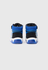 Wysokie buty sportowe z niebieskiej siateczki i czarnego materiału syntetycznego, z białą podeszwą i żółtym logo po boku.