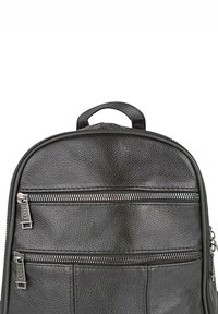 Mochila de cuero negro con superficie texturizada, dos bolsillos frontales con cremallera y un asa superior para llevar. Se pueden ver detalles en cremallera plateada.