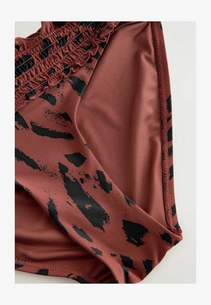 Bruine bikini-bottom gemaakt van gladde stof, met een zwart abstract patroon. Het heeft geraft detail bij de tailleband en een elastische rand.