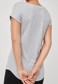 Kortærmet, grå t-shirt lavet af blødt, letvægtsstof med rund hals og opsmøgede ærmer. Sømløs rygdesign.