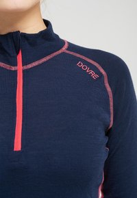 Marine zip-up trøje lavet af tekstureret stof, med rosa syninger og logo. Høj krave design med en kvart-længde lynlås.