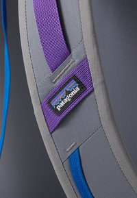 Γκρι μαλακή ζώνη με μοβ ταινίες, διαθέτει ραμμένο λογότυπο. Περιλαμβάνει μπλε ταινίες και λεία υφή.