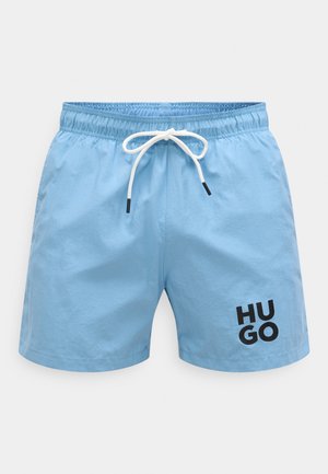 Svetlomodré plavkové šortky s elastickým pásom, bielym sťahovacím šnúrkou a čiernym logom "HU GO" na spodnej pravej strane.