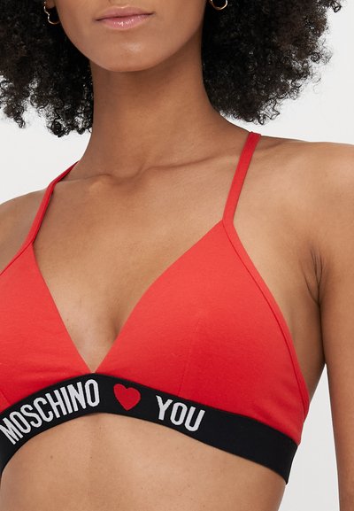 Bralet roșu în formă de triunghi cu bretele subțiri, având o bandă elastică neagră pe care este inscripționat textul "MOSCHINO ♥ YOU" cu litere albe.