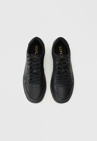 Czarne skórzane sneakersy z perforowanym wzorem, okrągłym czubkiem i płaskimi sznurowadłami. Posiadają złote logo "REPLAY" na języku.