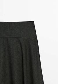 Jupe gris foncé taille haute avec une large ceinture et des plis souples en dessous, présentée sur un fond blanc uni.