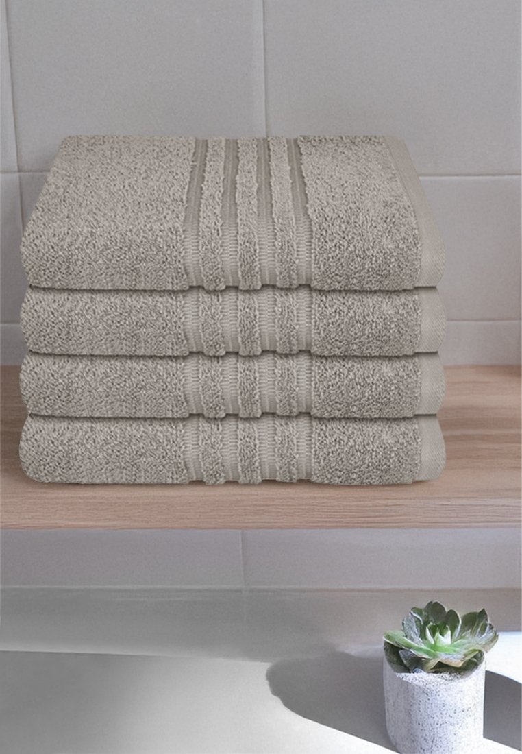 Quattro asciugamani grigio chiaro impilati, con accenti a strisce lisce e testurizzate in cima, posati su un ripiano di legno, accanto a una piccola pianta.