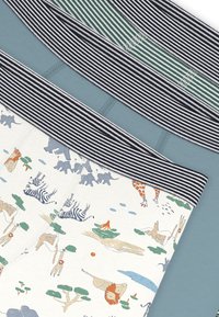 Τρία υφάσματα με σχέδια: το ένα με παιχνιδιάρικα ζωικά γραφικά σε κρεμ φόντο, το δεύτερο σε μονόχρωμο πράσινο-μπλε, και μια ριγέ μαύρη και λευκή μέση.