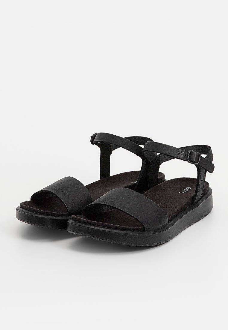 Schwarze Sandalen mit flacher Sohle, ausgestattet mit breiten Vorderriemen und einem sicheren Knöchelriemen mit Schnalle. Weiche schwarze Innensohle, minimalistisches Design.