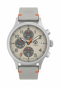 Montre Timex avec un boîtier en argent, un bracelet en cuir gris et des accents orange. Le cadran beige présente trois sous-cadrans, de grands chiffres et un affichage de la date.