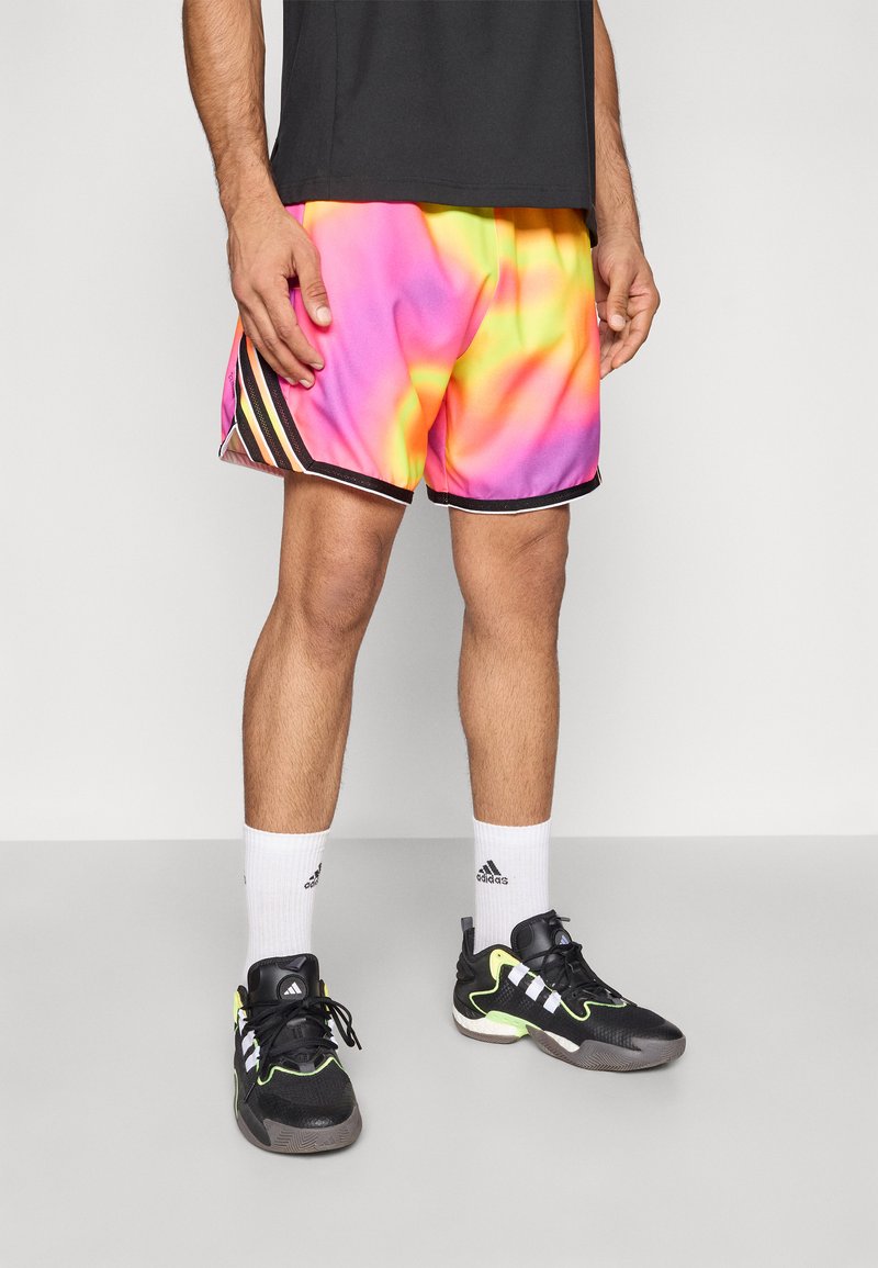 Krátke basketbalové šortky s viacfarebným prechodom od ružovej cez žltú po oranžovú, s čiernymi a bielymi bočnými pásmi. Čierne športové topánky.