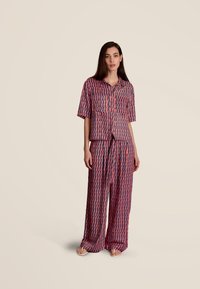 Korte mouwen geblokte shirt en bijpassende brede broek in rood, marineblauw en witte tinten, met een geometrisch design en een relaxte pasvorm.