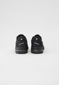 Baskets noires avec une tige en daim et mesh. Caractéristiques : logo et branding blancs contrastants, semelle coussinée et col rembourré.