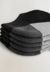 Fünf Paar Socken in einem Farbverlauf-Design in Schwarz- und Grautönen, aus strukturiertem Strickmaterial, mit gerippten Bündchen.