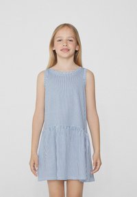 Robe sans manches avec des rayures verticales bleues et blanches, décolleté rond et jupe froncée. Fabriquée en tissu léger, elle présente une coupe décontractée.