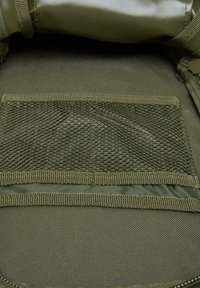 Olive green fabric storage compartment with mesh pocket. Features woven trim and smooth texture; suitable for organizing small items.