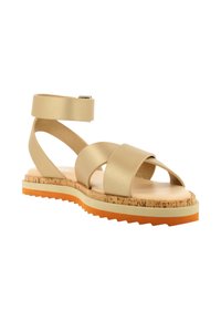Sandalbeige con dos correas anchas y hebilla en el tobillo, plantilla de corcho y suela de goma texturizada en naranja y blanco. Diseño plano, estilo de punta abierta.