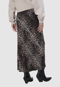 Maxi rok met luipaardprint in lichte stof, met zwarte, beige en bruine tinten. Gemaakt met pointed zwarte haklaarzen.