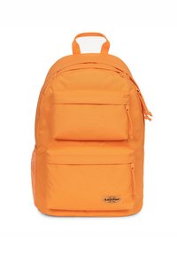 Oranžový látkový batoh s dvěma předními zipovými kapsami, boční síťovanou kapsou a horním úchopem. Disponuje nášivkou s logem na spodní straně.
